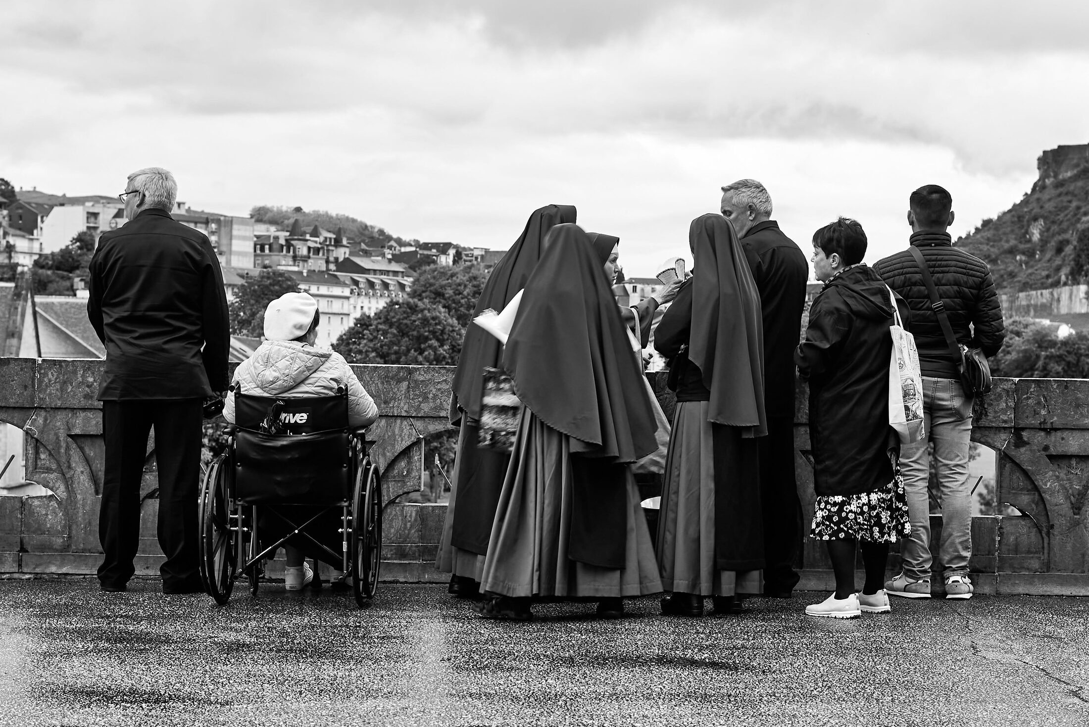 Clergy and visitors gather at an outdoor overlook.