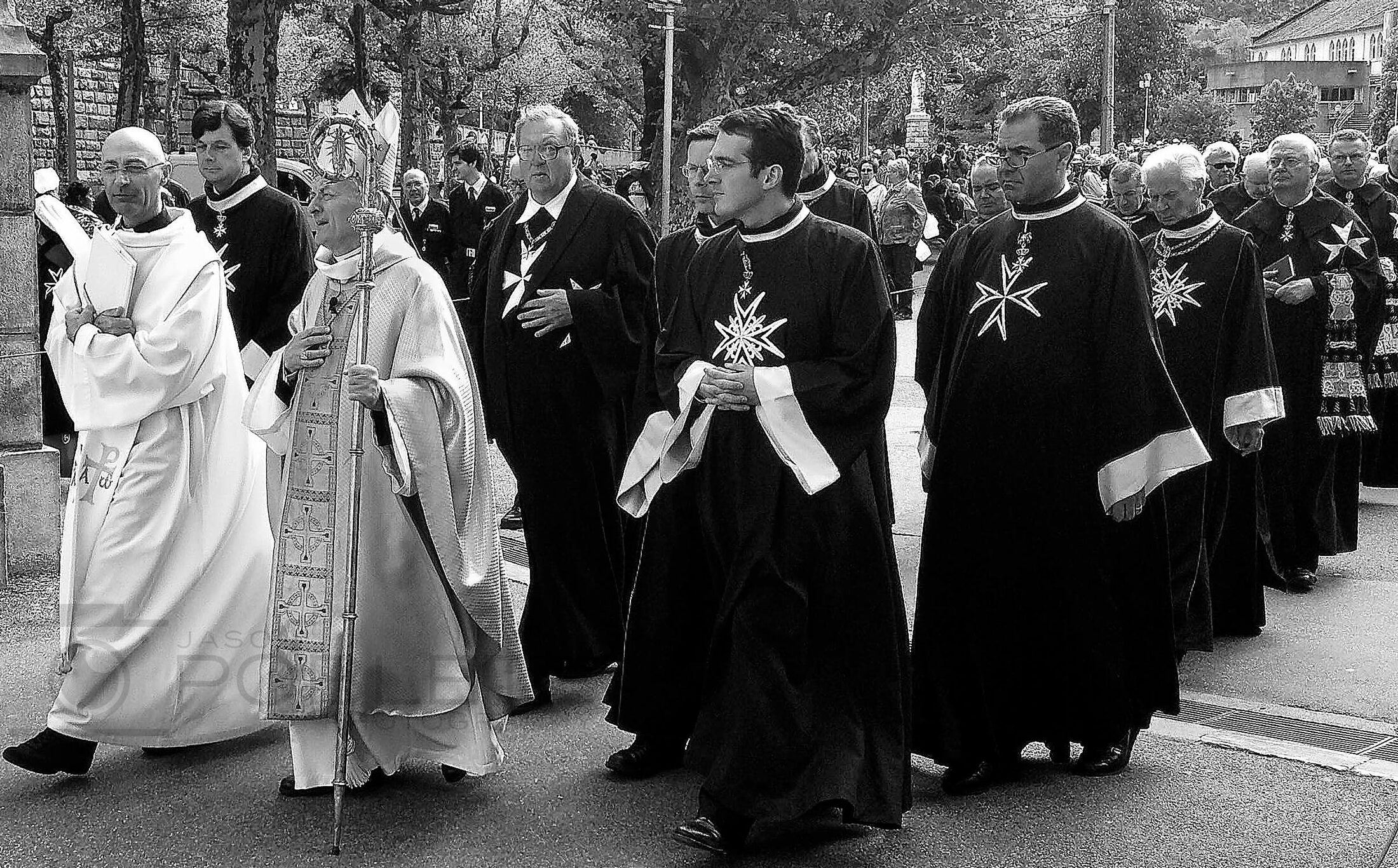 Clergy walk together in an outdoor procession.