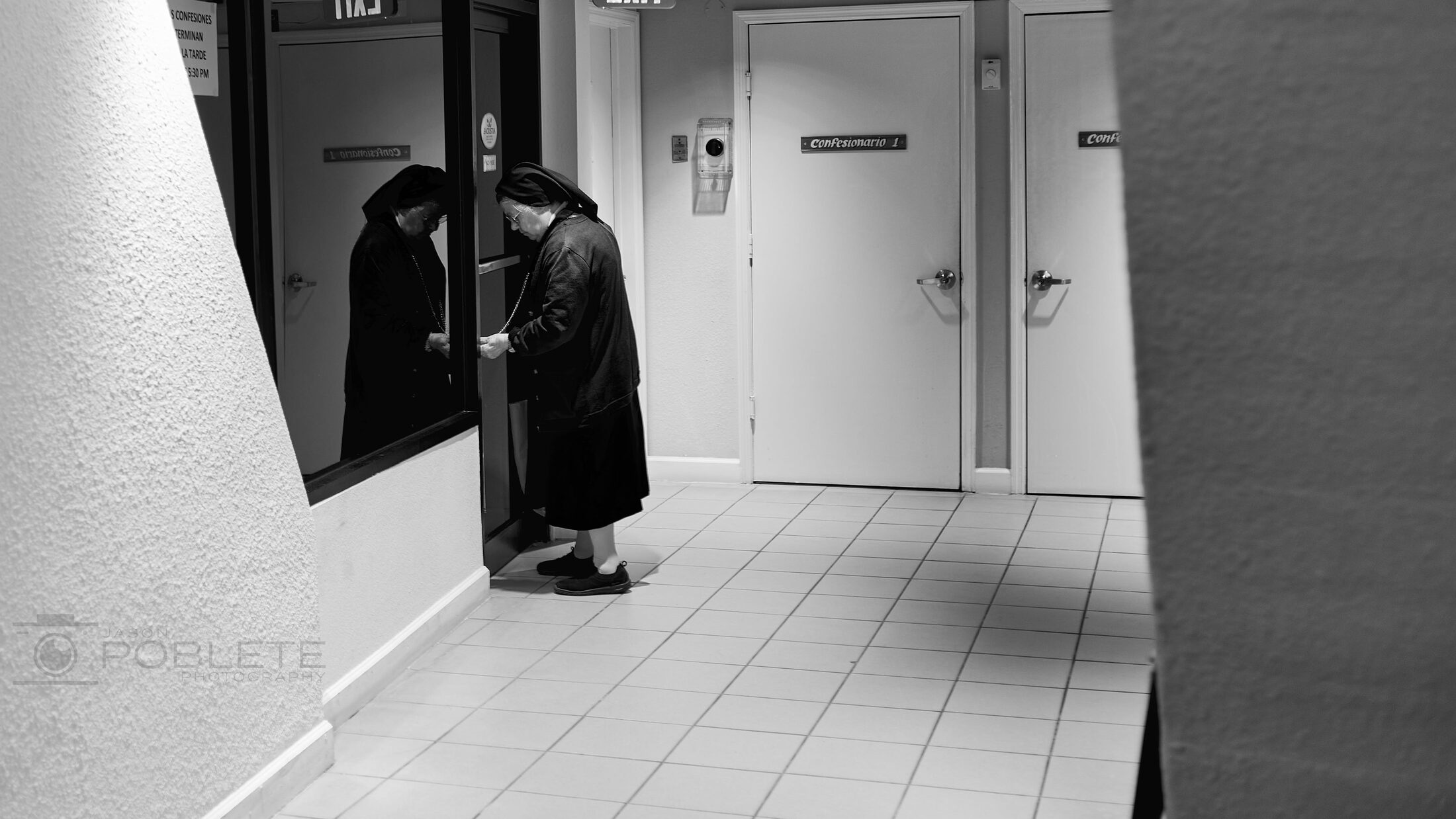 A lone person stands in a stark modern church interior.