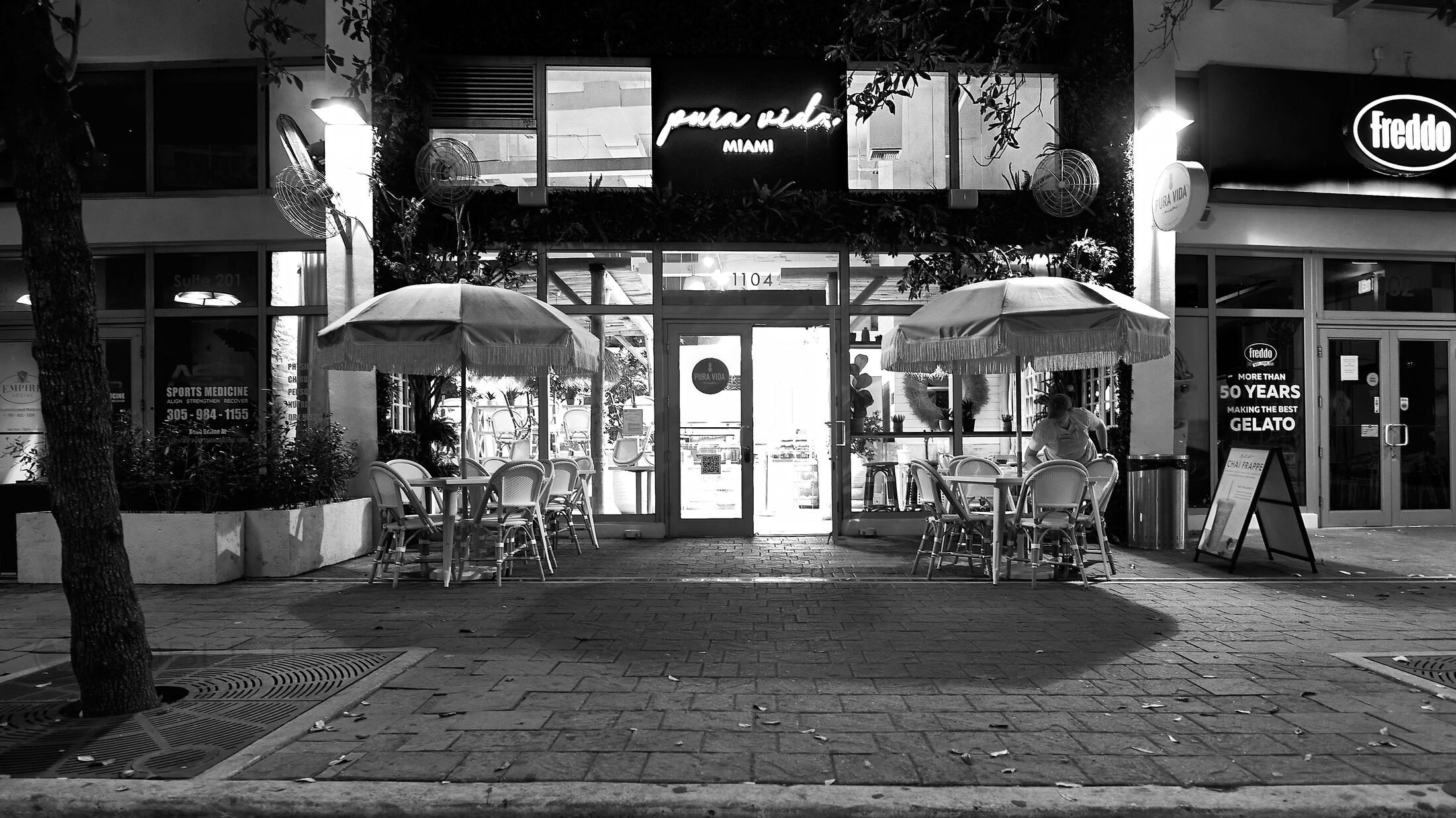 An illuminated food stand sits empty at night.