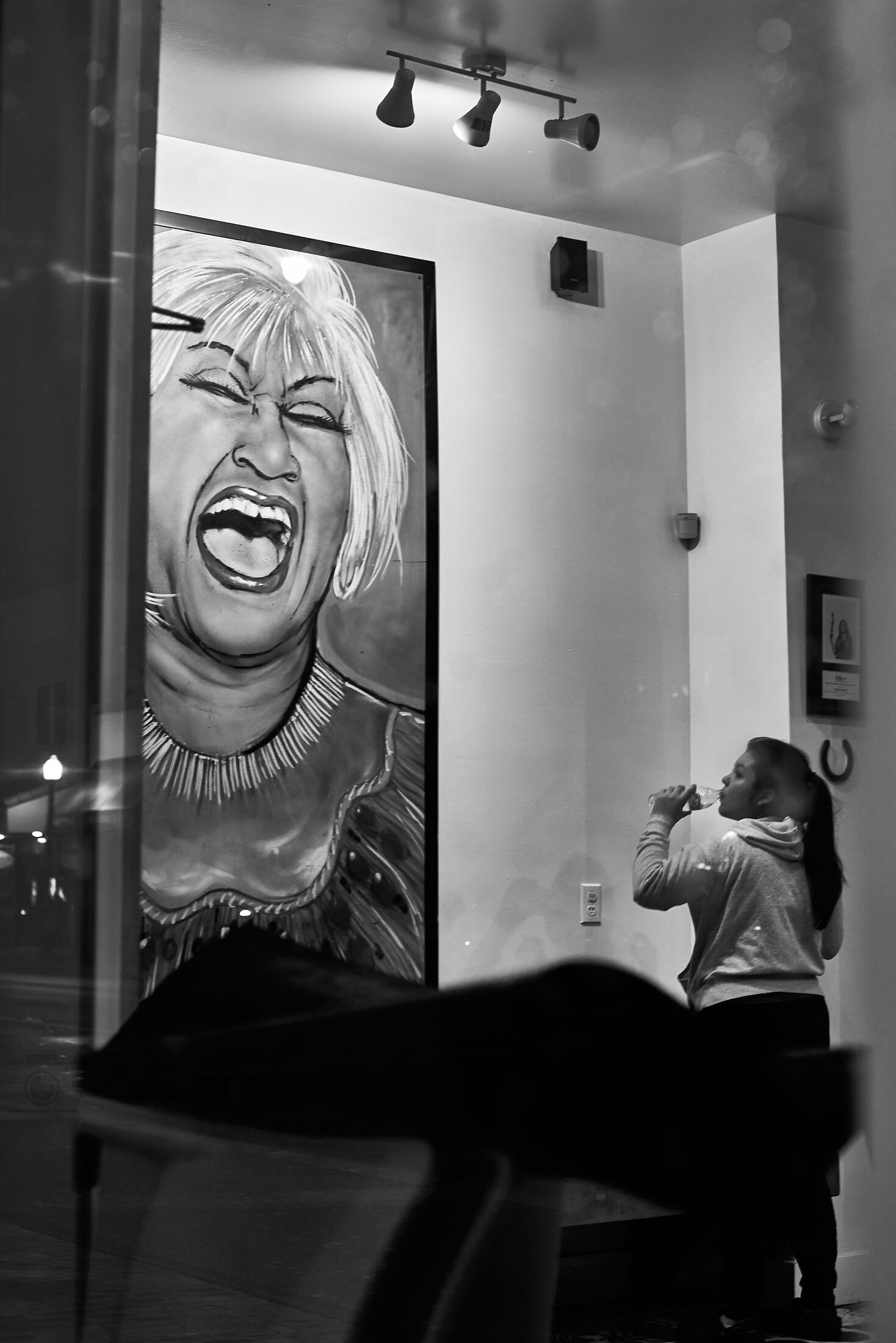 A laughing face appears on a wall advertisement inside a hallway.
