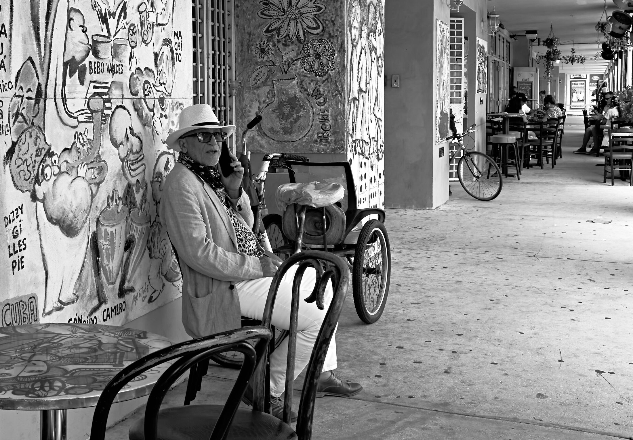 A person sits in a wheelchair outside a storefront.