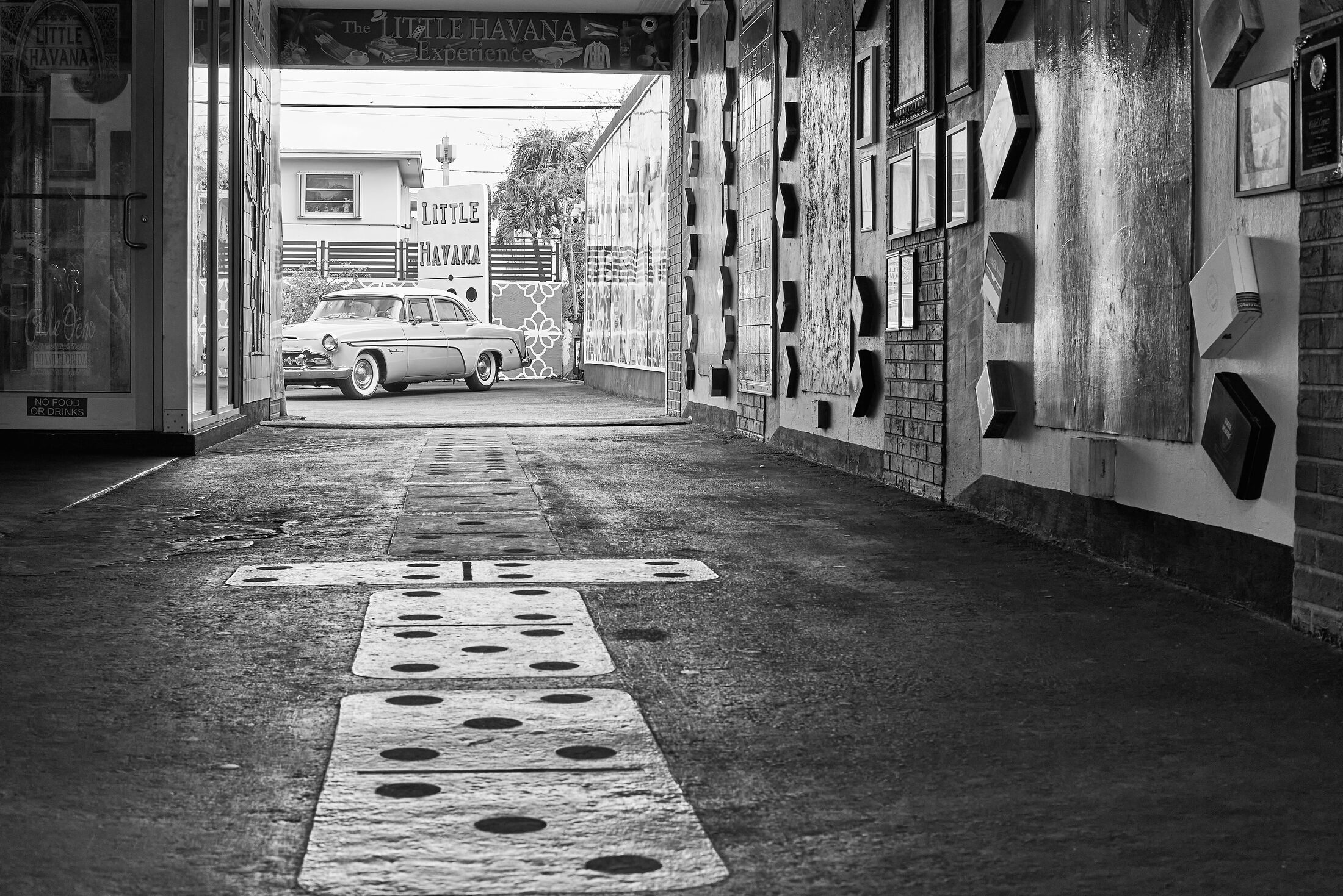 Sunlight forms a patterned path through an empty covered passageway.