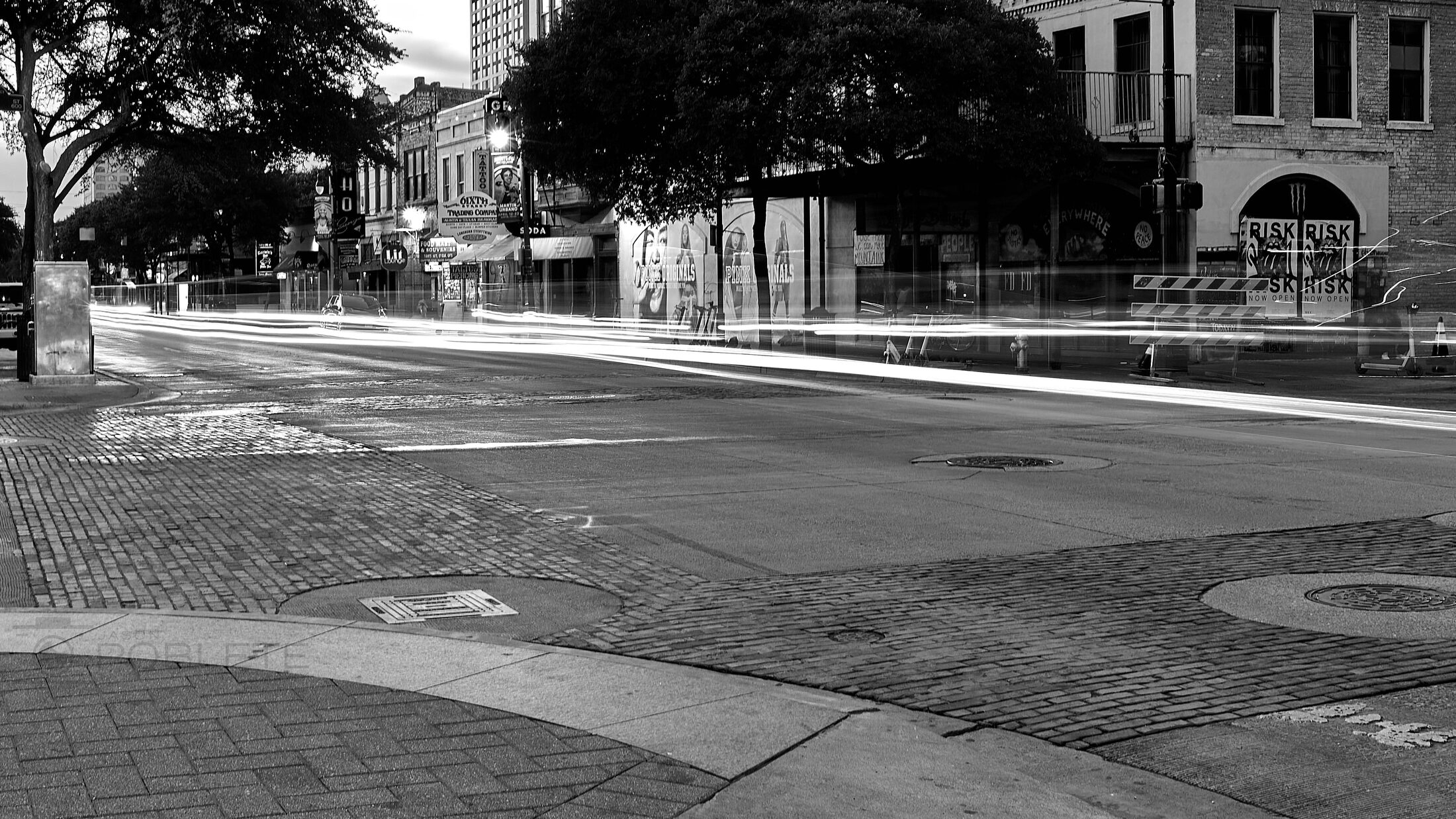 Sunlight and shadow form stark bands across an empty street corner.
