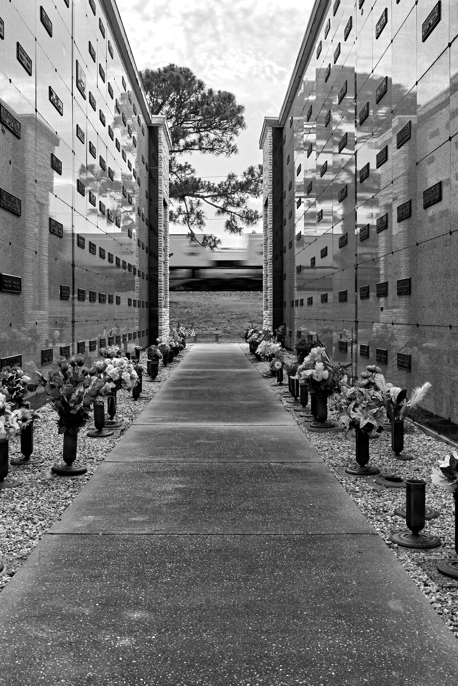 A long cemetery walkway recedes between walls of burial vaults.